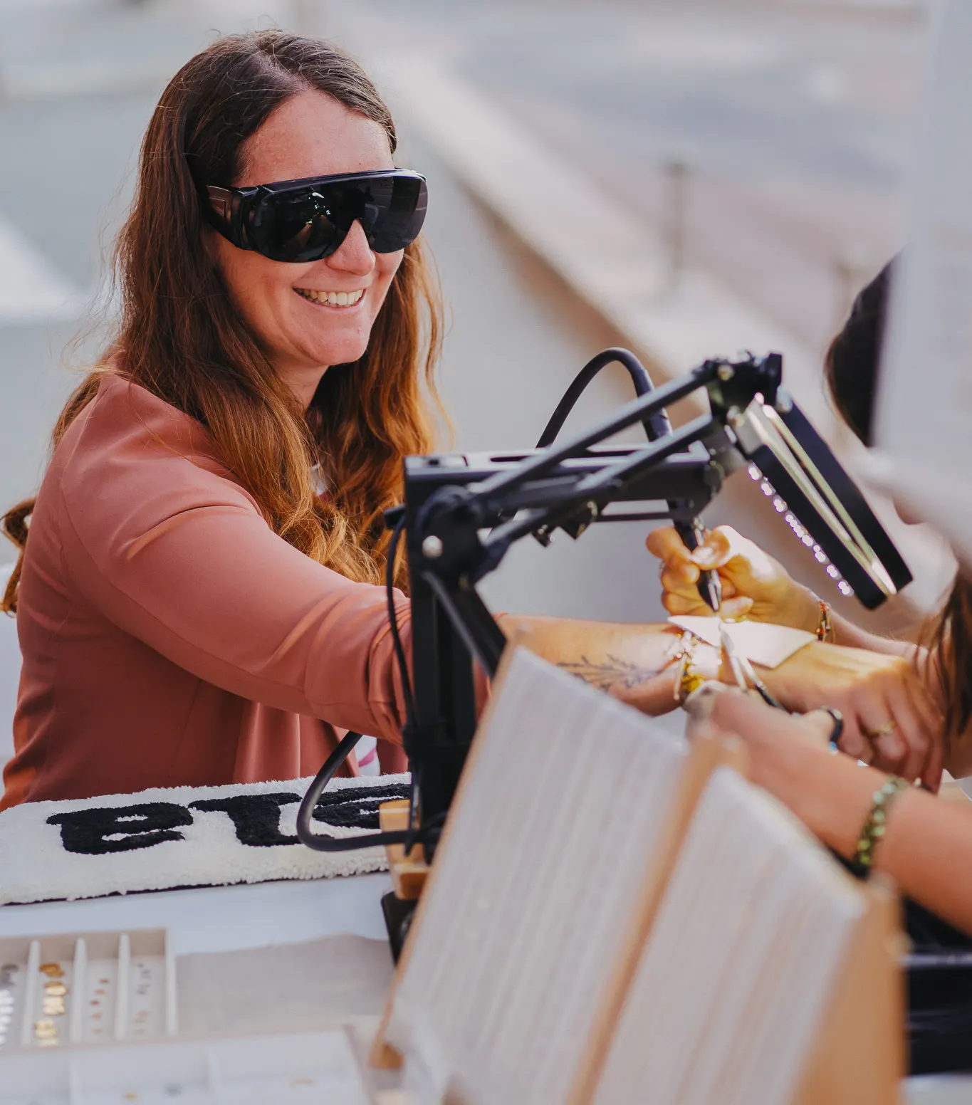 cliente souriante recevant un bracelet permanent lors d’une animation bijoux permanents